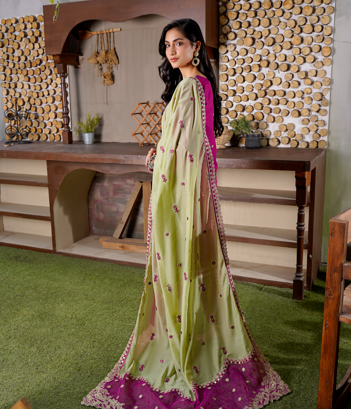 Woman in vibrant green and pink traditional Pakistani embroidered outfit
